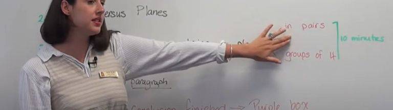 Teacher pointing to writing on a whiteboard