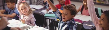 Students raising their hands in a classroom