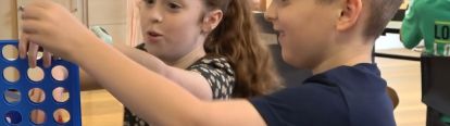 Two children playing connect 4 together