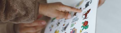 Child pointing at cartoon images of animals