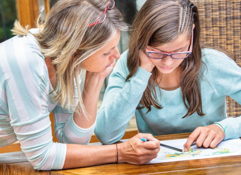 A teacher or parent helping a student with their work