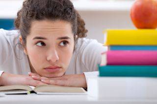 Student looking uninterested, resting chin on hands