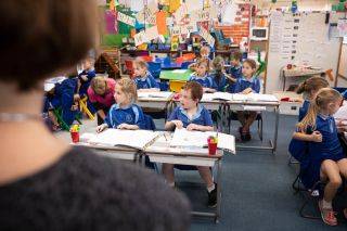 Students pay attention while referencing their work books