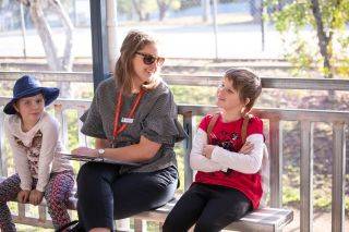 Teacher sits and talks with students