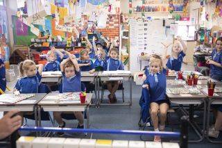 Students raising their hands in class