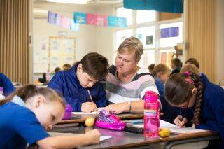 A teacher helping a student with a writing task